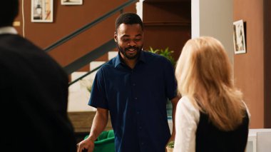 Tropikal sahil oteline kayıt yaptırmak için bekleyen çeşitli çiftler yaz tatilinde seyahat ediyorlar. Uluslararası turistler egzotik otel resepsiyonunda lobide resepsiyon görevlileriyle konuşuyor..