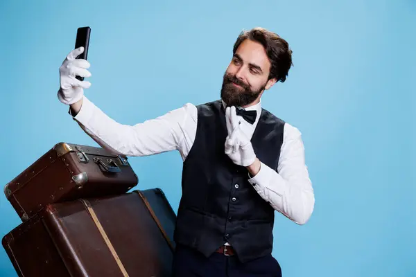 Bellboy Con Corbata Toma Selfies Estudio Usando Teléfono Inteligente Para —  Fotos de Stock