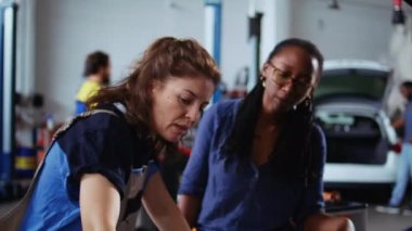 Garajda uzman bir tamirci müşterinin tamirini bitiriyor, kalan yağ sızıntılarını da araçtan çıkarıyor. Uzman, tamir atölyesinde Afro-Amerikan müşteri otomobilinin parçalarını temizliyor.
