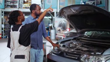 Araba tamir atölyesindeki mühendis, araba performans parametrelerini görselleştirmek için artırılmış gerçeklik teknolojisi kullanıyor. Önerilen araç güncellemelerini göstermek için AR hologramını kullanan kadın