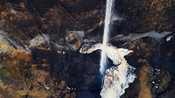 轰鸣的野生曲棍球从结冰的悬崖峭壁上流淌而下 冰岛美丽的瀑布在冰原上从山上流下来 壮观的全景 慢动作 — 图库照片