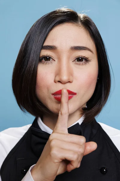 Poważna Azjatka Mundurze Kelnerki Trzymająca Palec Wskazujący Ustach Pokazująca Gest — Zdjęcie stockowe
