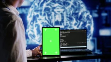 Başlangıç çalışma alanında yapay zeka kodları yazmak için yeşil ekran tableti kullanan sertifikalı bir yönetici. Yapay zeka sistemlerini güncelleyen yüksek teknolojili kurumlarda bakım işi yapan uzman.