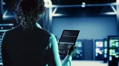 Tablet, sorun çözme ve süper bilgisayarlar, ağ sistemleri ve depolama dizileri için tasarlanmış yüksek teknoloji kurulum ekipmanlarını güncellemek üzere çalışan bilgili bir kadın.