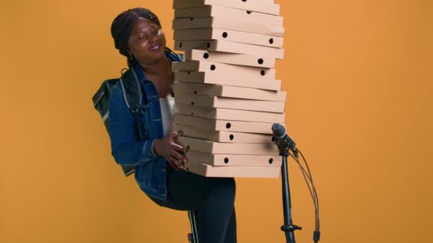 年轻的黑人女人手里拿着一堆披萨盒 准备送到邻居家庆祝活动 非洲裔美国人送货时谨慎地平衡了大量的食品送货订单 — 图库视频影像
