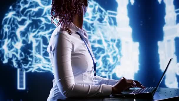 非裔美国妇女在笔记本电脑终端上的创业工作空间中编写人工智能脚本代码 努力工作的员工在高科技设施更新的人工智能系统中做维护工作 — 图库视频影像