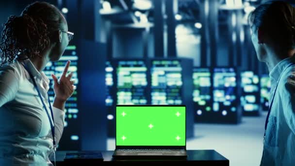 It开发人员在绿色屏幕笔记本电脑上运行代码 解决数据中心设备的问题 技术人员使用彩色关键设备监测服务器机柜 网络系统和存储阵列 — 图库视频影像