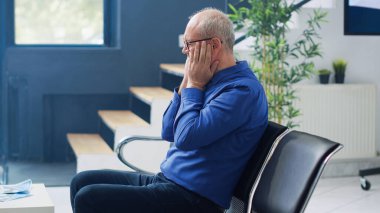 Stresli kıdemli adam hastane lobisinde pratisyen hekimle görüşmek için bekliyor, danışmadan önce Chiar 'da oturuyor. Yaşlı bir hastanın tıbbi randevusu var. İlaç servisi.