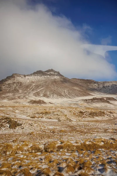 凍った牧草地と山の鎖は アイスランドの道端の牧草地 ノルディックな丘や土地の近くで雪に覆われています アイスランドの凍った畑や雪山を含む北極圏の自然 — ストック写真