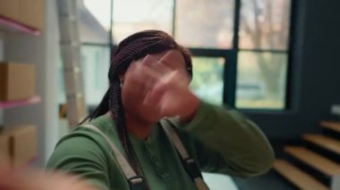 Afrikalı Amerikan depo çalışanı yönetici yöneticilerle çevrimiçi video görüşmesine katılmak için selfie akıllı telefon kamera kullanıyor. Dağıtım merkezi yöneticileriyle telekonferans toplantısında çalışan işçiler