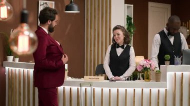 Otel resepsiyonunda kontrol ediliyor. Resepsiyon çalışanı, iş adamının pasaport bilgilerini inceliyor. Beyaz yakalı işçi uzun bir iş uçuşundan sonra tatil köyüne geliyor..