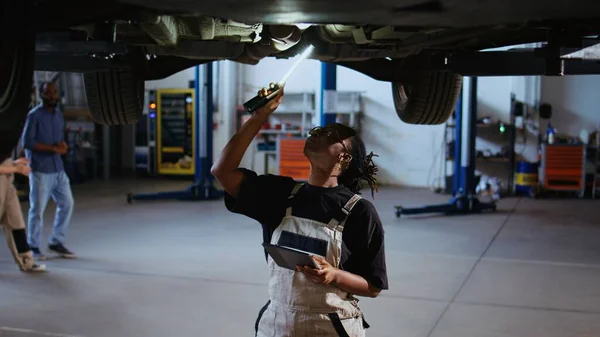 Engenheiro Qualificado Sob Carro Suspenso Oficina Reparação Usando Luz Trabalho — Fotografia de Stock