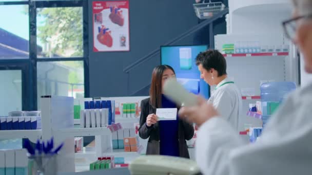Vásárló Gyógyszertárban Aki Orvosi Véleményt Kér Gyógyszerésztől Miközben Polcokon Lévő — Stock videók