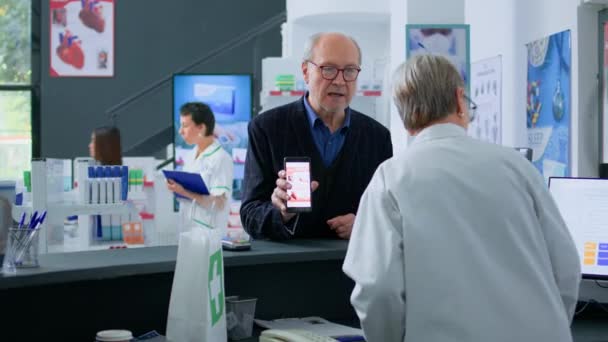 Hombre Mayor Mostrador Farmacia Mostrando Imagen Las Píldoras Cardiovasculares Prescritas — Vídeo de stock