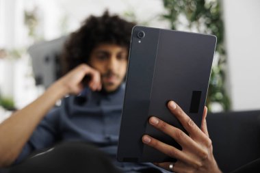 Genç Arap girişimci, iş yerinde çalışırken dijital tablet üzerine makale okuyor. Şirket yöneticisini başlat proje pazarlama stratejisi sunumunu kontrol et