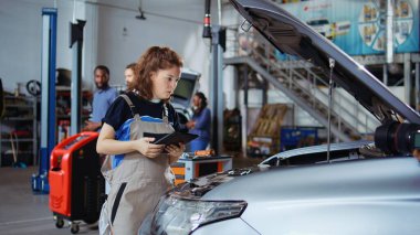 Onarım sırasında araba performans parametrelerini kontrol etmek için dizüstü bilgisayar kullanan sertifikalı bir tamirci. Hasarlı aracı incelemek için garajda cihaz kullanan bir uzman.
