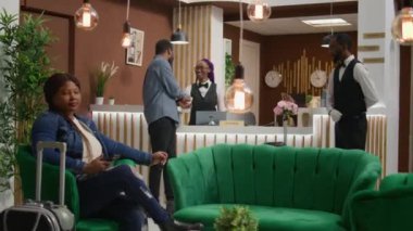Modern otelde turist kaydı yaptırmak ve oda giriş kartı almak, personele konukseverlik endüstrisi konforu ve kolaylıkları hakkında konuşmak. Resepsiyonist kadın resepsiyondaki adamı karşılıyor..