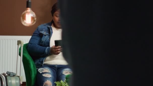 Gość Weryfikuje Teksty Smartfonie Podczas Oczekiwania Rejestrację Hotelowym Lobby Afrykański — Wideo stockowe