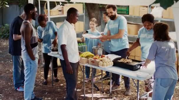 Młodzi Wolontariusze Środowisk Kaukaskich Afroamerykańskich Dają Mniej Szczęściarzom Darmowe Jedzenie — Wideo stockowe