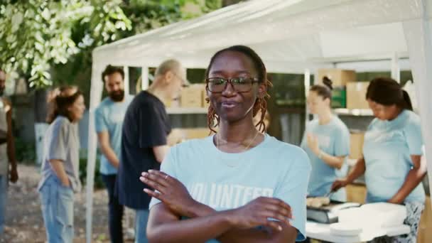 アフリカ系アメリカ人女性の肖像画は カメラに固定された腕と目で外に眼鏡をかけている 食糧運転では ボランティアは貧しい人々 貧しい人々 ホームレスの人々を助けています ズームアウト ハンドヘルド — ストック動画