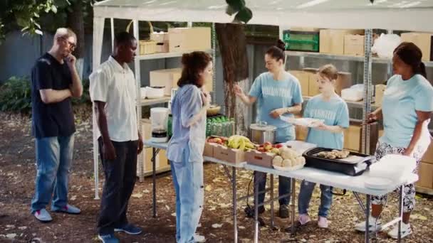 Благодійному Харчуванні Волонтери Діляться Положеннями Їжею Безпритульними Молоді Люди Пропонують — стокове відео