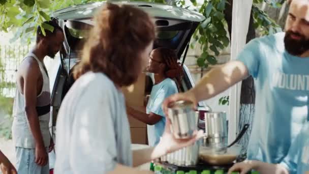 人道主义援助队以微笑和协作的方式向贫穷的无家可归者提供支助 车上的非洲裔美国女志愿者把捐款箱送给了穷人 三脚架射击 — 图库视频影像