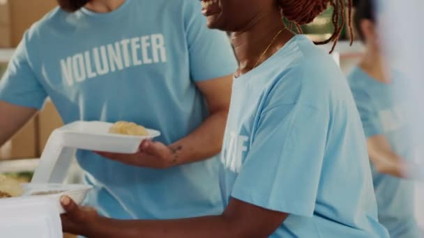은행에서 가난하고 궁핍한 사람에게 식사를 배포하는 친절한 여성에 초점을 맞추십시오 — 비디오