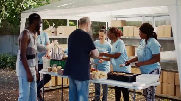 在无家可归者收容所 人道主义援助团体参与向有需要的人分配捐款 志愿人员通过提供膳食和通过非营利粮食银行提供援助来作出贡献 — 图库视频影像