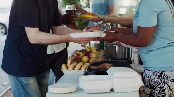 Sidovy Över Unga Volontärer Som Serverar Mat Till Behövande Och — Stockvideo