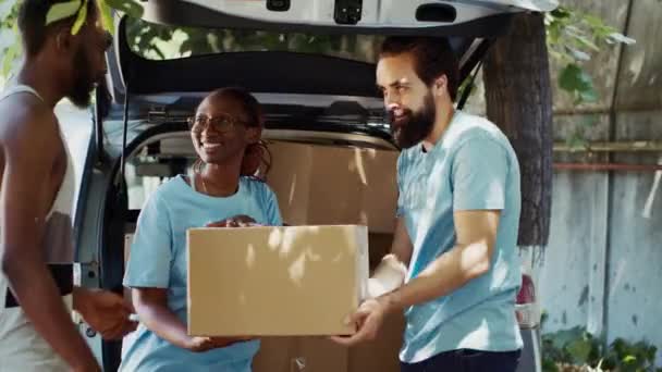 车上的男女志愿者在社区中心为贫穷和无家可归的人捐赠了慈善盒 在食物运动中 较弱势的人接受非营利组织的捐赠 — 图库视频影像