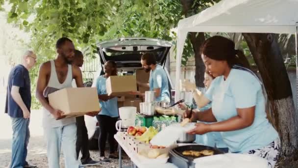 各群体向无家可归者和难民住所的需要者分发捐款箱 多种族志愿人员通过非营利粮食银行分享基本物品和提供支助 — 图库视频影像