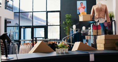 Moda kıyafetlerle dolu boş modern bir butik, askılarda ve raflarda modaya uygun ürünleri olan bir perakende mağazası. Alışveriş merkezinde moda aksesuarlarla donatılmış giyim mağazası. Moda konsepti