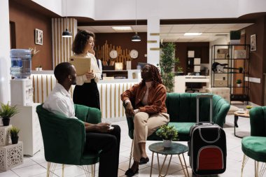 Yönetici misafirlere hizmet veriyor, insanlara oda rezervasyonu hakkında konuşuyor. Otelin lobisinde oturan çift, tatil köyünde lüks bir konaklama için bekliyorlar..