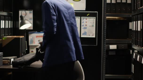 オフィスに入るラップトップバッグを持っている私立探偵が働き始める アフリカ系アメリカ人警察官がパソコンを机の上に置き 容疑者の事件情報をレビュー — ストック動画