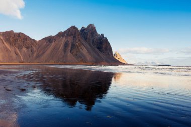 Yükselen Alp Vestrahorn tepeleri, Stoksnes yarımadasındaki İzlanda 'nın fantastik ortamı. Donmuş İzlanda 'daki sevimli siyah kumlu İskandinav manzarası.