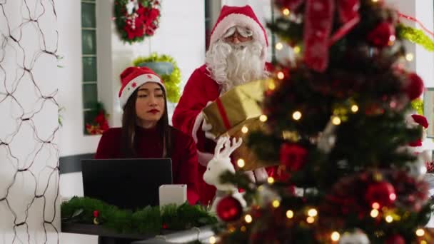 Ασιάτης Εργαζόμενος Λαμβάνει Δώρα Από Γενναιόδωρη Συνάδελφο Ενεργεί Άγιος Βασίλης — Αρχείο Βίντεο