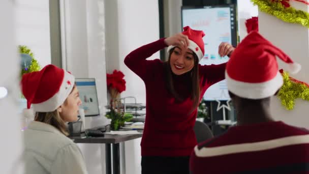 休憩中に怪物のふりをして 同僚を楽しませるクリスマスの帽子をかぶっている従業員 冬のホリデーシーズン中にXmasオープンオフィスでパントマイムを楽しんでいるスタッフ — ストック動画