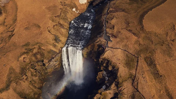 从空中俯瞰着冰原上的巨大瀑布 河水从自然结冰的山丘流下 美丽的北欧骷髅瀑布从悬崖上流下 形成了令人惊奇的冰山一角风景 慢动作 — 图库照片