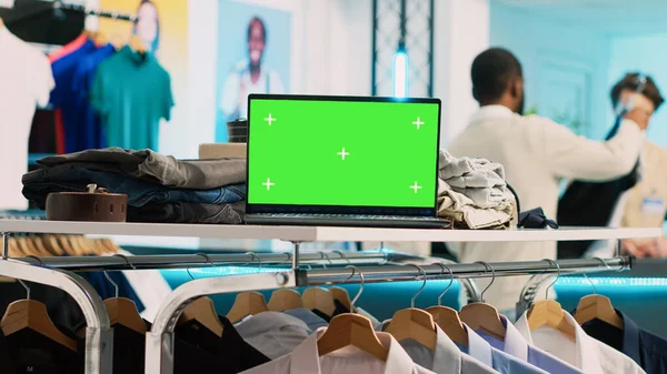 Modern pc with greenscreen template in clothing shop, running blank chroma key display on screen. Shopping center store with isolated mockup copyspace, small business retail market.