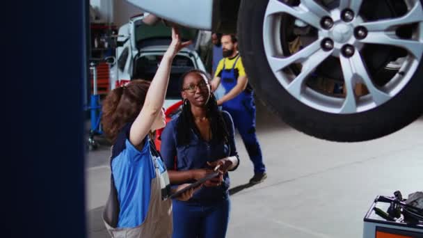 Pomocny Mechanik Klient Stojący Pod Samochodem Garażu Pomocą Tabletu Aby — Wideo stockowe
