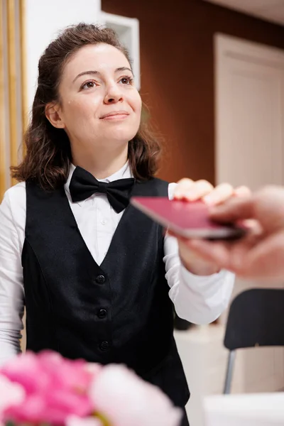 Female Concierge Eagerly Welcomes Assists Elderly Traveler Checks Identification Check — Stock Photo, Image