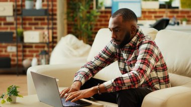 Konforlu modern apartman ofisinde uzaktan çalışan bir işçi iş buluyor. Evden tele-sekreter çalışıyor, klavyeye yazıyor ve kameraya gülümsüyor, yavaş çekim yakın çekim.