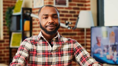 Uzaktan kumandalı işçi evde güzel bir dairede otururken sıkıcı monoton işleri bitirmeye odaklanmış. Afrika kökenli Amerikalı tele-işçi işini yaparken mutlu, yavaş çekimde yakın çekim.