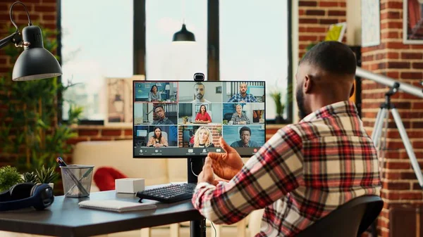 Samimi apartman dairesinde çalışan bir çalışan video konferans sırasında iş arkadaşlarıyla tartışıyor. Uzaktan çalışan çeşitli uluslararası ekiple çevrimiçi video görüşmesi yapılıyor.