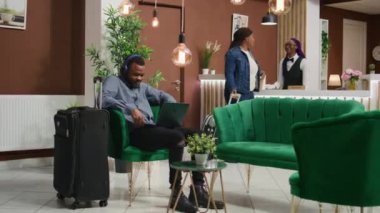 Müşteri, beş yıldızlı lüks bir tatil köyünde lobide kontrol edilmeyi beklerken dinlenme odasında film izliyor. Afro-amerikan otel misafiri bilgisayarı kullanarak resepsiyona kayıt olmaya hazırlanıyor..