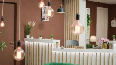 Konuk kaydı ve yeşil koltuklarla dekore edilmiş dinlenme odası için kullanılan zarif otel resepsiyonu. Boş lobi masası, şık mobilyalarla gezginleri karşılamaya hazır..