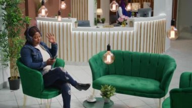 Afrika kökenli Amerikalı müşteri telefonda müzik dinliyor, beş yıldızlı tatil beldesinde tatilin tadını çıkarıyor. Otelin lobisine vardıktan sonra konaklamayı bekleyen genç turist, resepsiyona kaydolun..