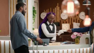 Misafirler harika bir tatilden sonra giriş kartını resepsiyona bırakıp prosedürü kontrol edip evlerine dönüyorlar. Afrikalı Amerikalılar otel kapıcılarına büyük hizmetleri için teşekkür ediyorlar. El kamerasıyla..