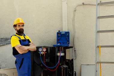 Tamir edilmiş klimanın önünde duran profesyonel mühendisin portresi yapıldı. Müşteri tarafından sözleşmeli yetenekli teknisyen Hvac sistem bileşenlerinin sorunsuz bakımıyla mutlu