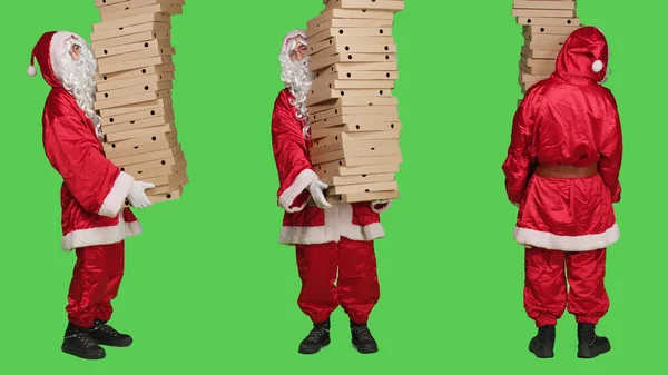 Saint nick holding pizza boxes, delivering huge pile of fast food over full body greenscreen. Santa claus embodiment wearing traditional december costume with white beard, carton packages.